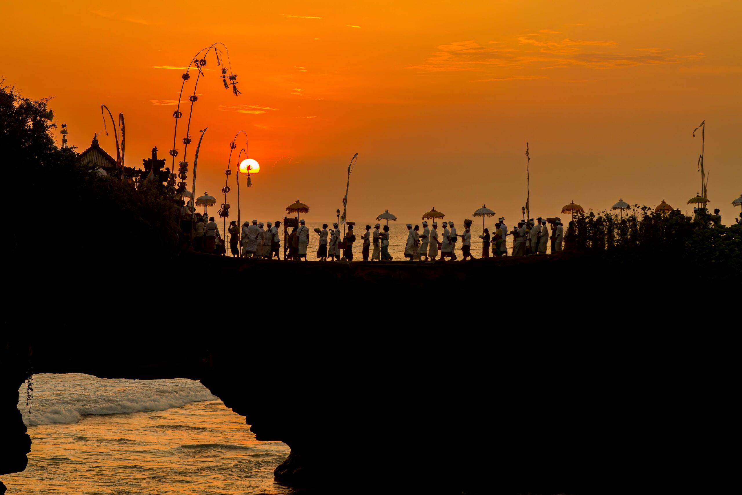 Balinese Hindu worshippers walking toward Pura Batu Bolong temple near Tanah Lot, Bali, Indonesia