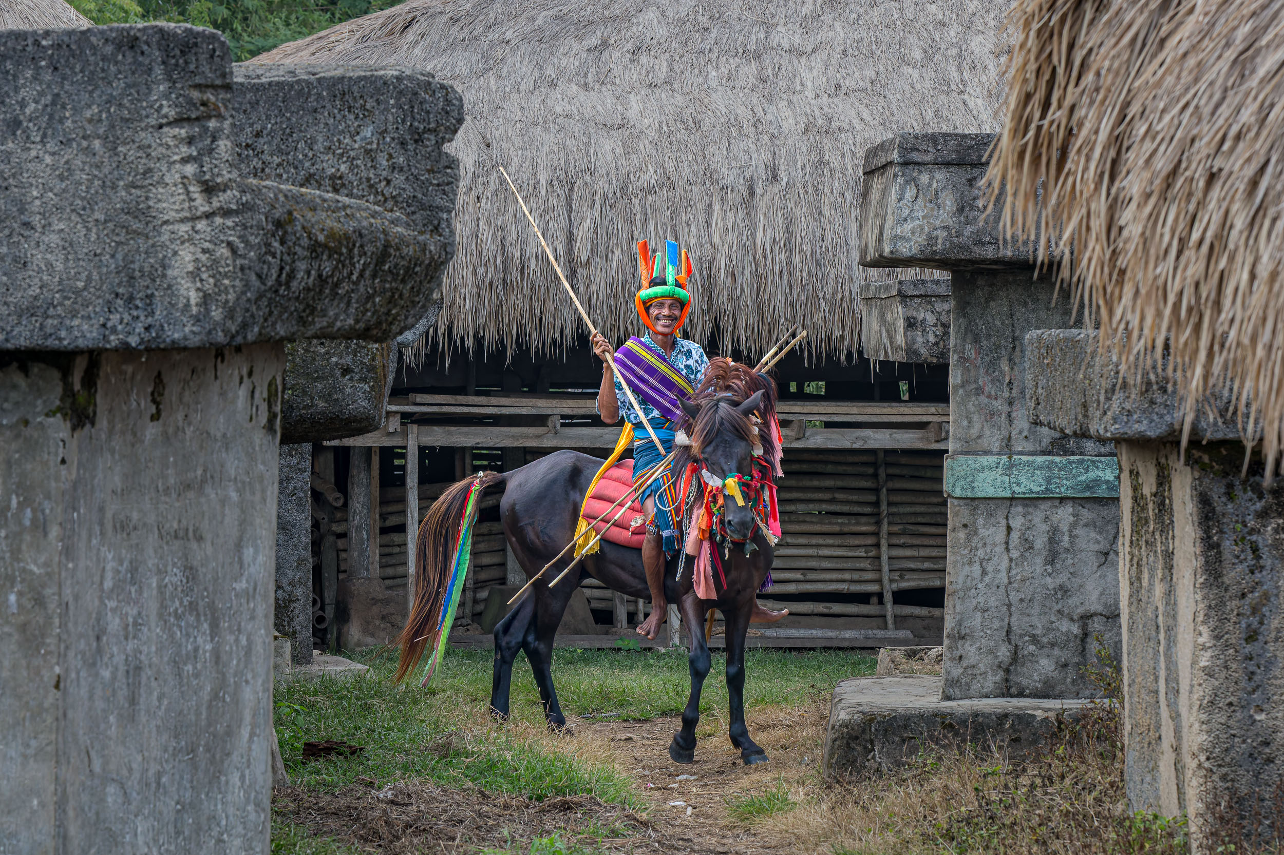 Pasola riders preparing their horses and wooden spears in the village before the ritual battle begins.